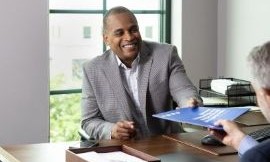 Financial professional handing documentation to a client across a desk